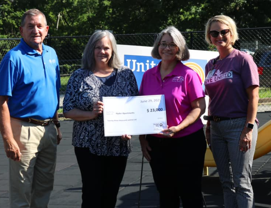 Dennis Muller, Tamara Hellmann, Cindy Reeves accepting United Way check for $23,000 for the purchase of a new bus.